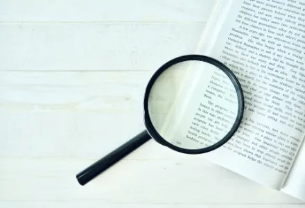 虫眼鏡と本の画像